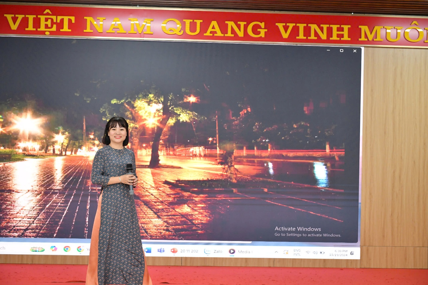 A person standing in front of a large poster
Description automatically generated