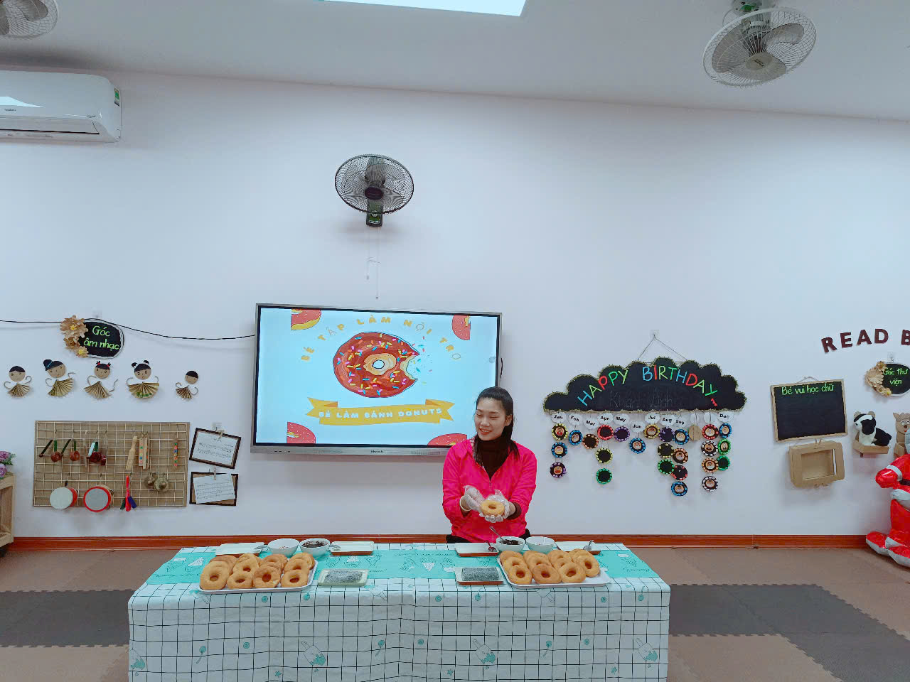 A person standing in front of a table with donuts
Description automatically generated