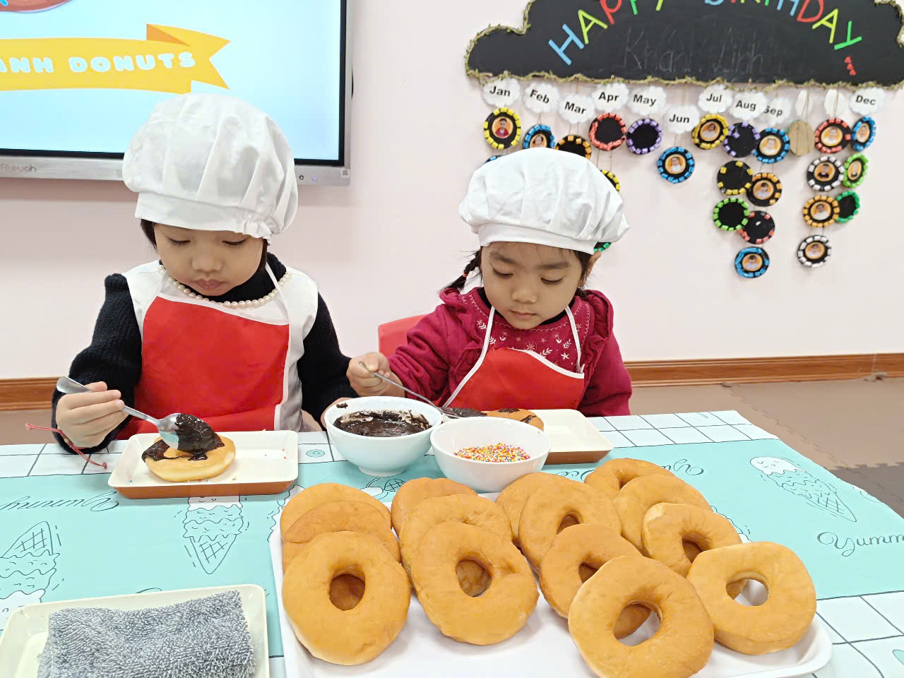 A couple of children wearing chef hats and aprons
Description automatically generated